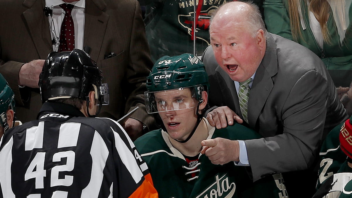 An NHL ref explains a call to an angry coach.