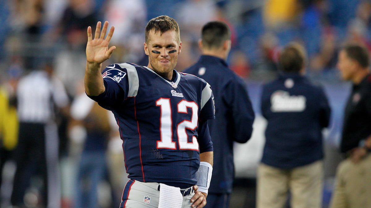 Tom Brady holds up 5 fingers to show how many Super Bowl rings he has won for the Patriots.