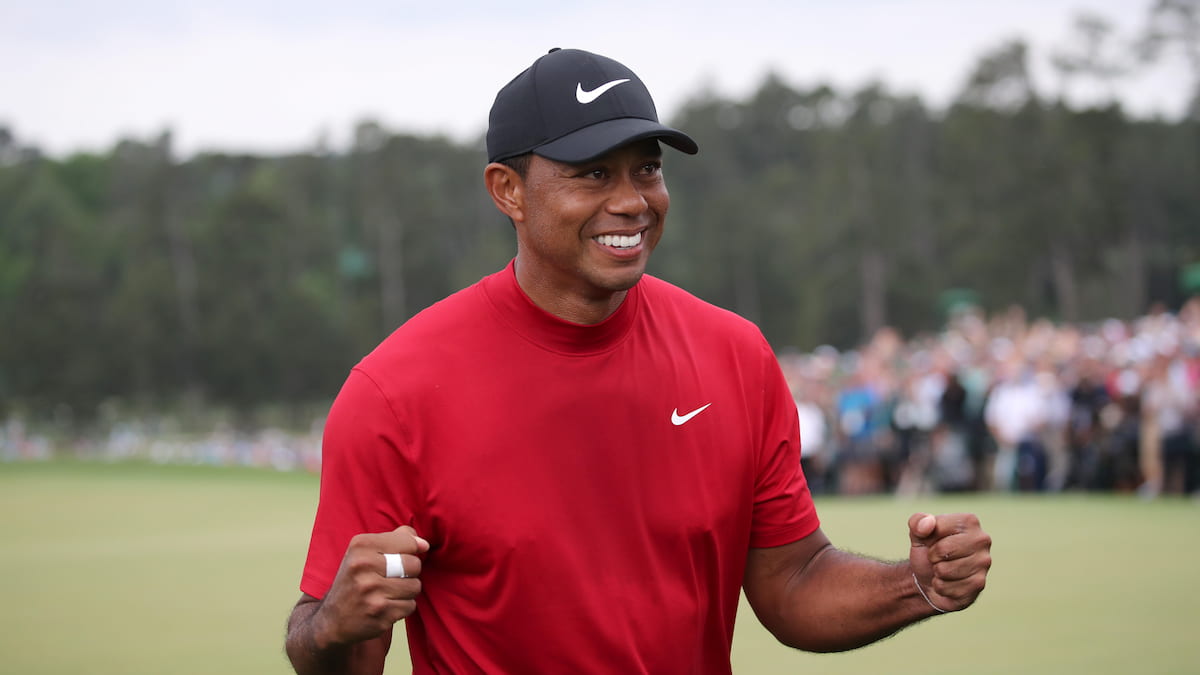 Tiger Woods wearing his trademark red shirt celebrates a victory