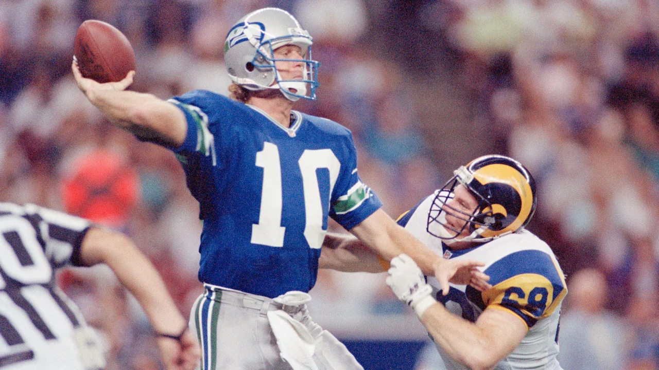 Seahawks quarterback Dan McGwire towers over a defender while throwing a pass in the NFL.